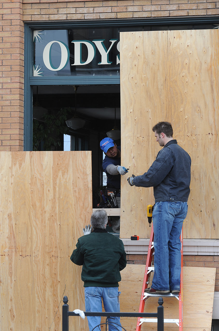 Workers cover a window